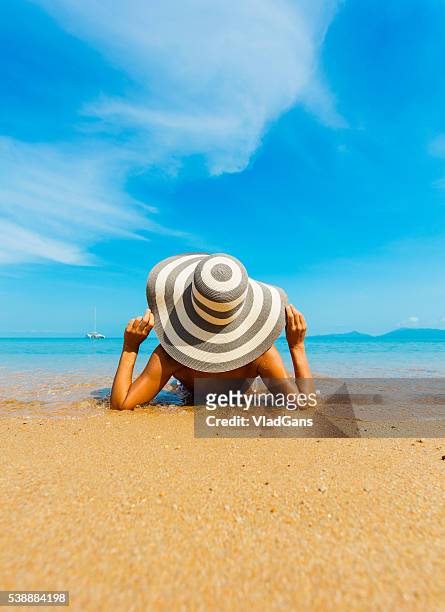 woman at tropical beach - brown hat stock pictures, royalty-free photos & images