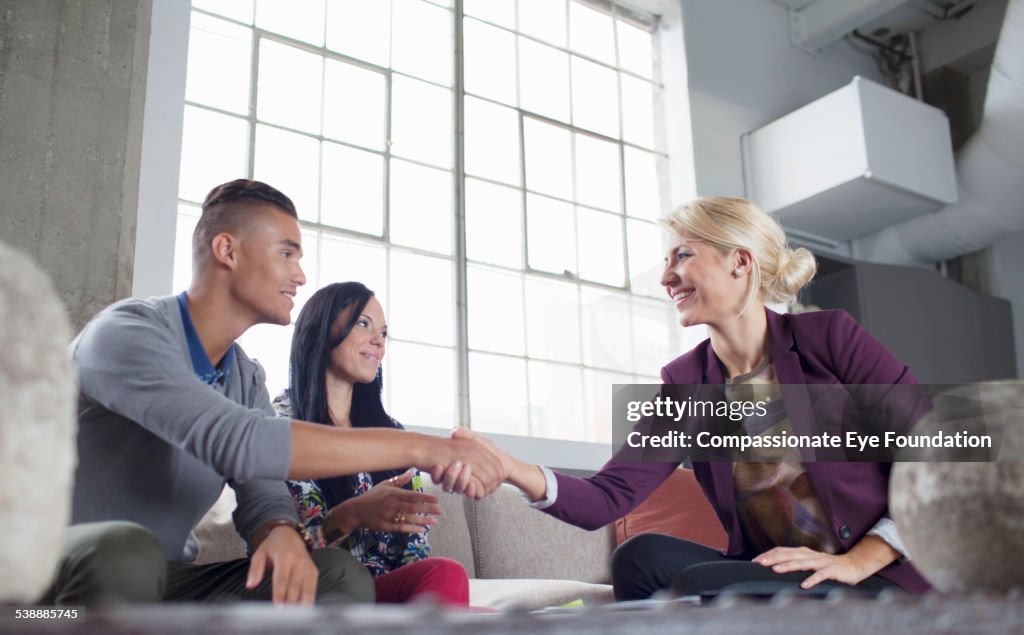 Couple shaking hands with financial adviser