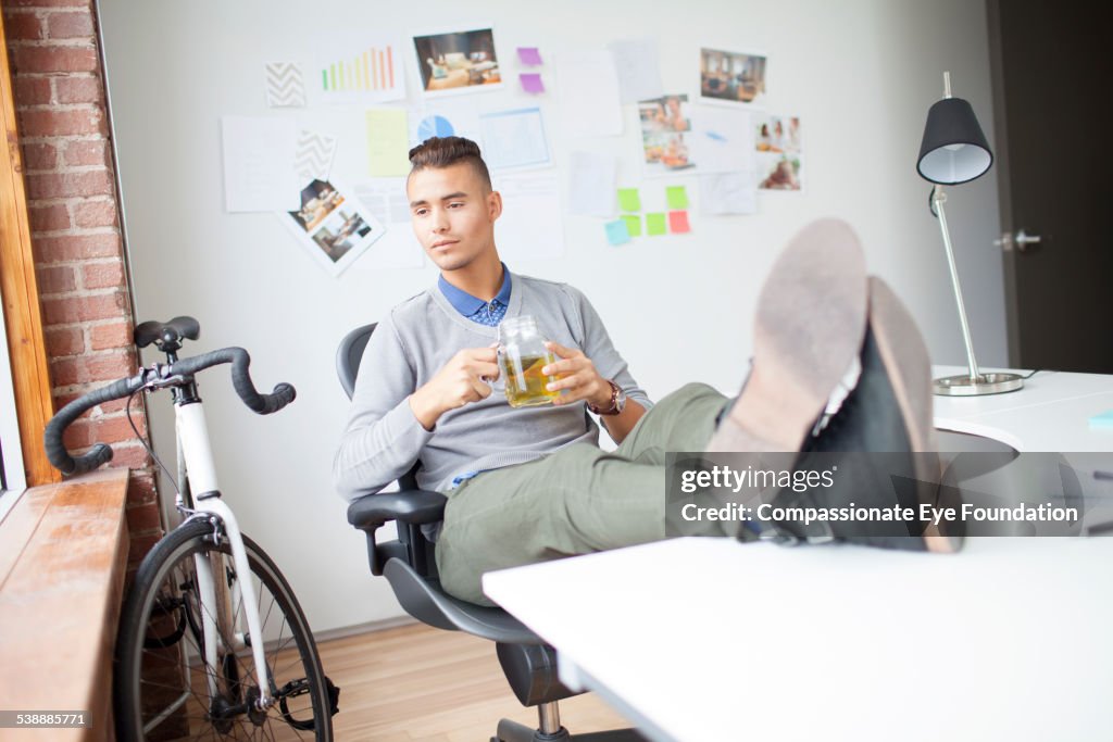 Businessman enjoying cup of tea in office