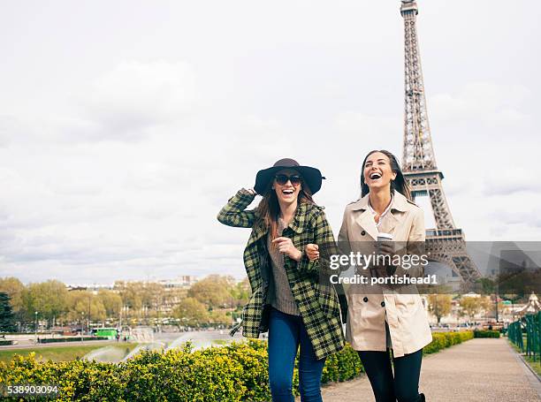 cheerful young women having fun in front of eiffel tower - paris autumn stock pictures, royalty-free photos & images