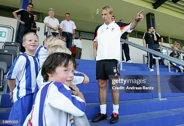 Coach Juergen Klinsmann talks to kids before the training session of the German National Team on September 1, 2005 in Berlin, Germany. Germany will...