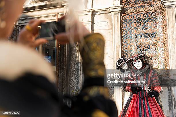 mask taking photo of couple, carnival, san zacharias, venice, europe - venetiaans masker vasthouden stockfoto's en -beelden