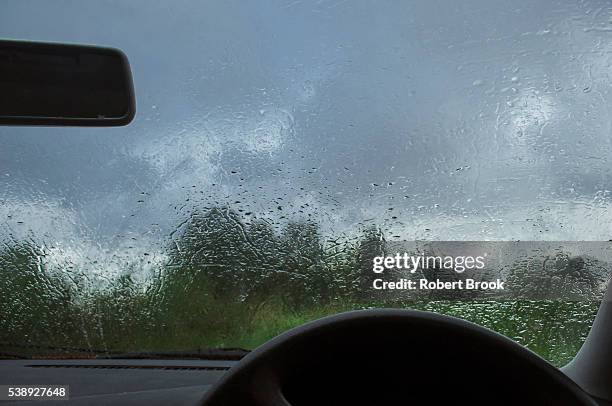 obscured view through rain spattered windscreen of car - covered car stock-fotos und bilder