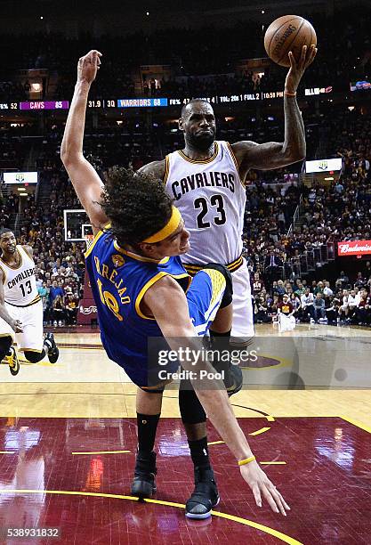 Anderson Varejao of the Golden State Warriors falls as LeBron James of the Cleveland Cavaliers drives to the basket during the second half in Game 3...