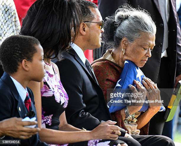 Nola Whitfield hugs the flag after it was presented to her during the Military funeral service for her husband, 2LT Malvin Greston "Marvelous Mal"...