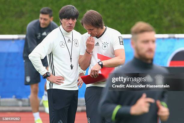 Joachim Loew, head coach of the German national team talks to his assistant coach Thomas Schneider during a Germany training session ahead of the...