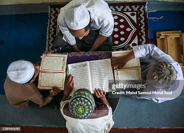 Muslim Rohingya refugees read the Koran inside the Madrasah during the holy month of Ramadan on June 9, 2016 in Klang outside Kuala Lumpur, Malaysia....