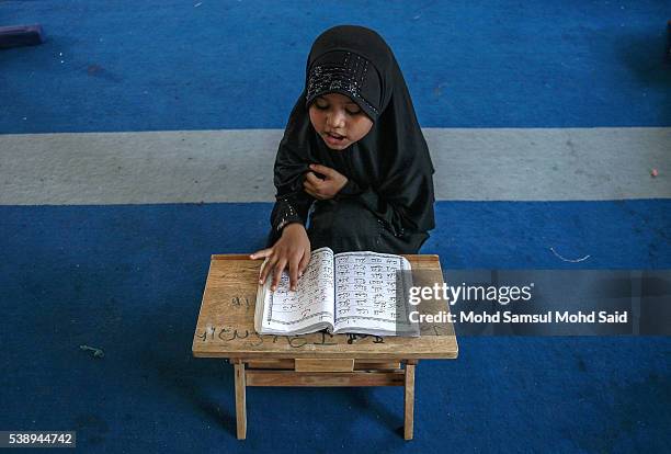 Muslim Rohingya children read the Koran inside the Madrasah during the holy month of Ramadan on June 9, 2016 in Klang outside Kuala Lumpur, Malaysia....