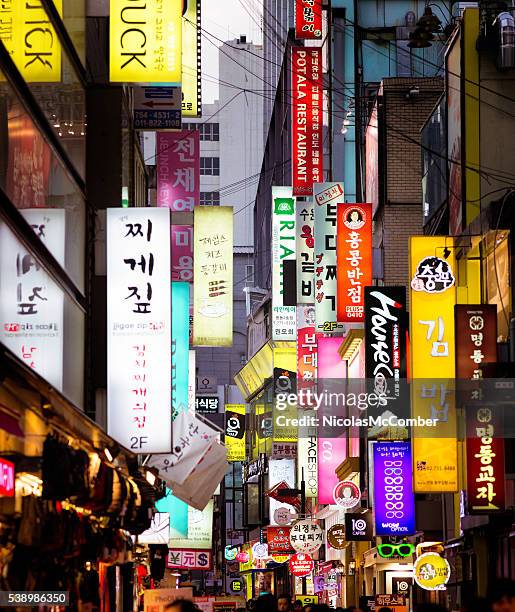 multiple illuminated commercial signs in seoul street at dusk - seoul bildbanksfoton och bilder