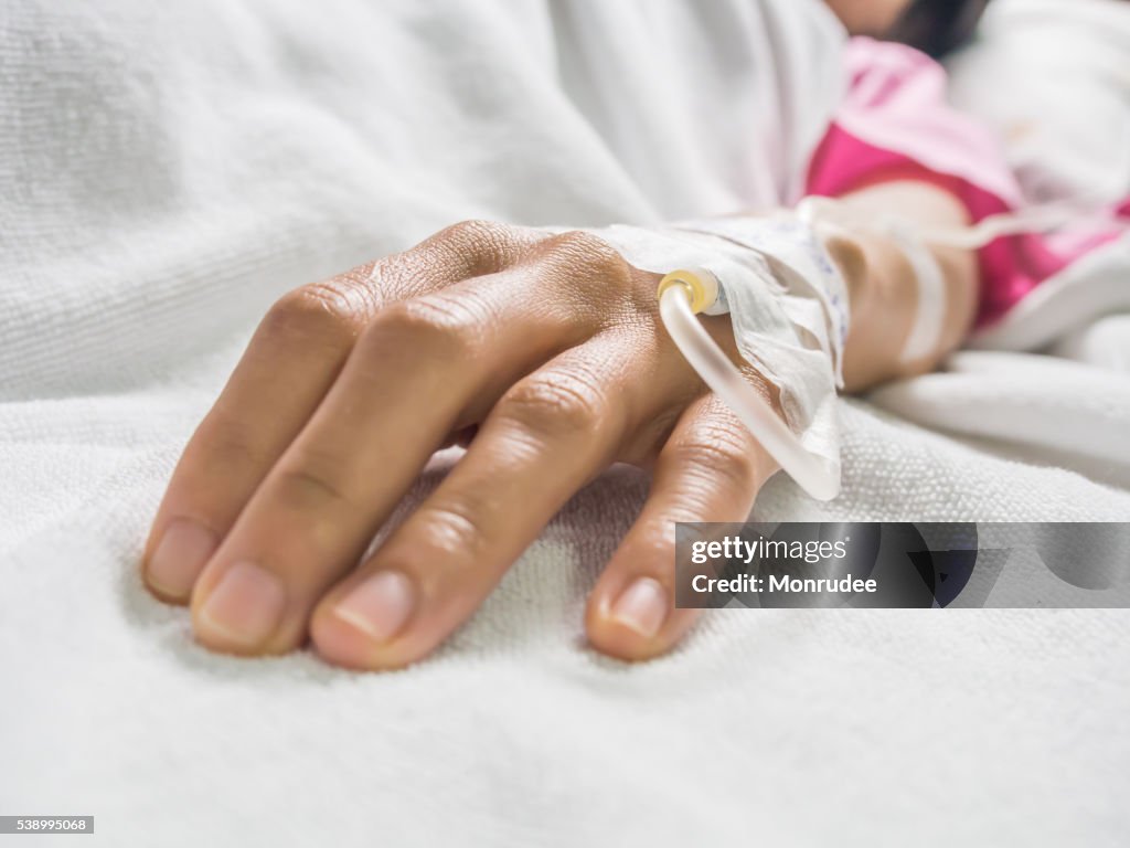 Saline intravenous (iv) drip in a sick women patient hand.