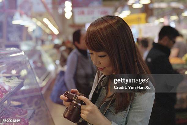 girl looking at her camera - granville island market stock pictures, royalty-free photos & images