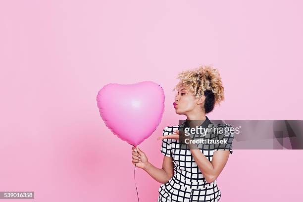 young woman with big pink heart - blowing a kiss stockfoto's en -beelden