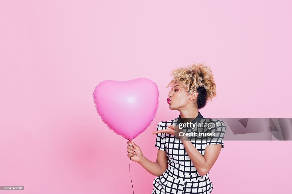 Mulher jovem com grande rosa coração