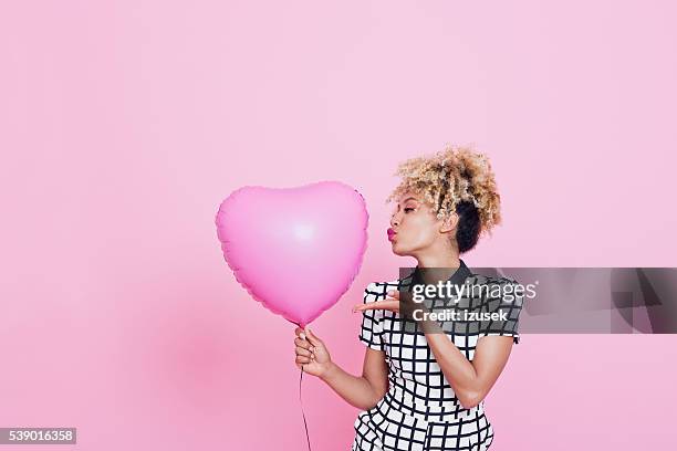 young woman with big pink heart - blowing a kiss bildbanksfoton och bilder