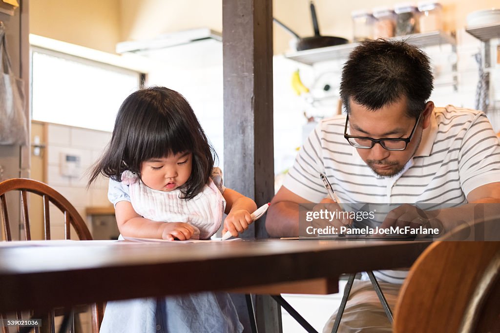 Japanische Vater und Tochter beim Ausfüllen Papierkram im Küchentisch