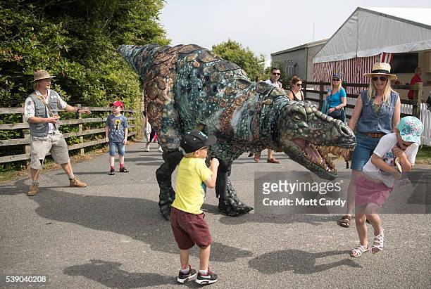 People react to the Eden Project's life-size juvenile Tyrannosaurus rex that has been brought as a preview to the nearby attraction's "Dinosaur...
