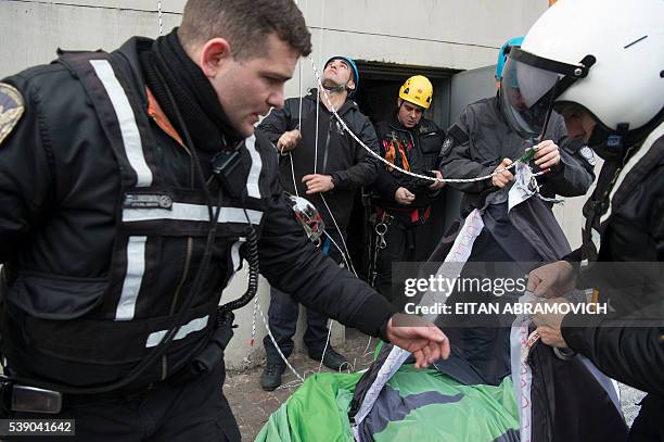 Police officers remove a banner unfurled by Greenpeace activists at the Obelisk of Buenos Aires on June 09 to ask president Mauricio Macri greater...