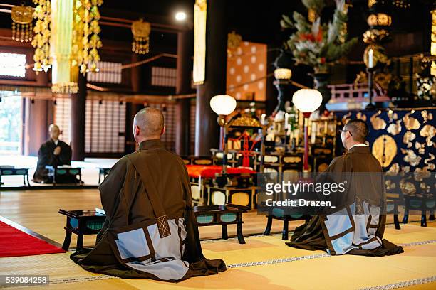 budistas durante a oração no templo budista em quioto - ceremony imagens e fotografias de stock