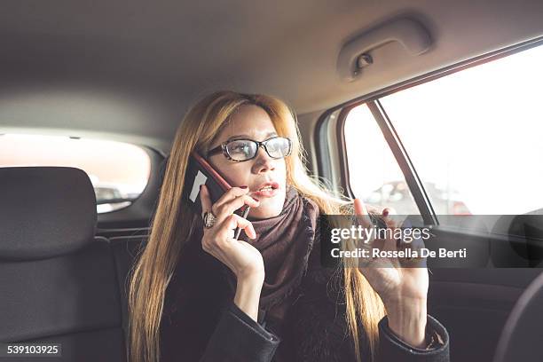 businesswoman using smartphone - one woman only videos stock pictures, royalty-free photos & images