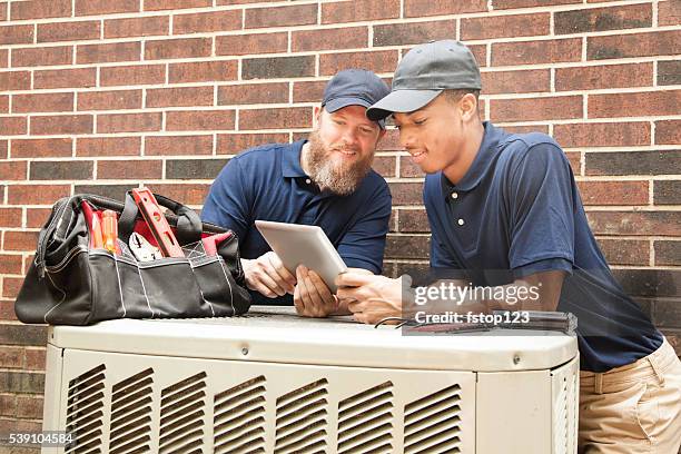 climatisation unité réparateurs travailler à la maison. tablette numérique. - chauffage-ventilation-et-climatisation photos et images de collection
