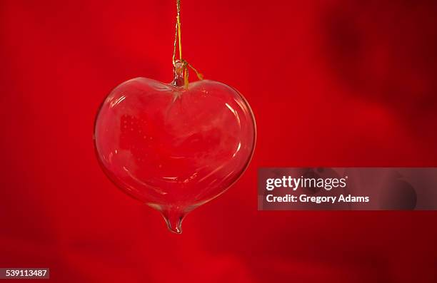 glass heart hanging in front of a red background - hatboro fotografías e imágenes de stock