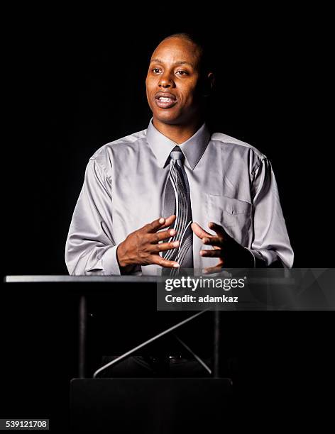 african american man making a speech at a podium - priests talking stock pictures, royalty-free photos & images