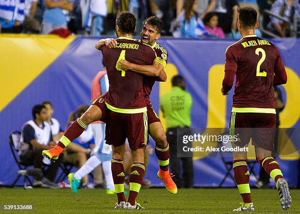 Tomas Rincon of Venezuela celebrates with teammate Oswaldo Vizcarrondo after winning a group C match between Uruguay and Venezuela at Lincoln...