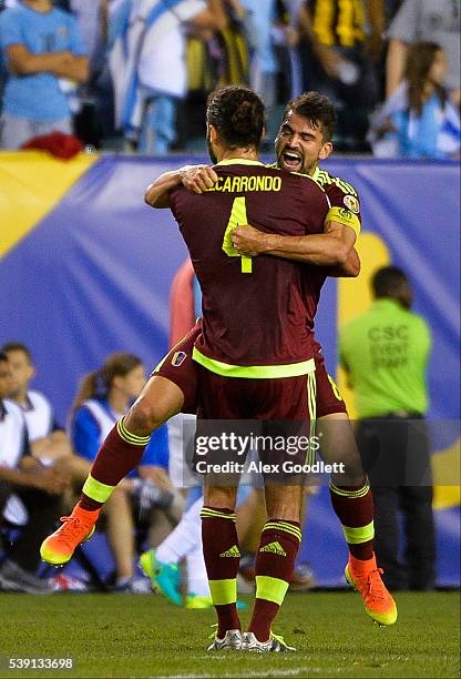 Tomas Rincon of Venezuela celebrates with teammate Oswaldo Vizcarrondo after winning a group C match between Uruguay and Venezuela at Lincoln...