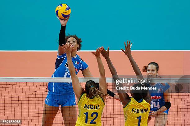 Valentina Diouf of Italy spikes the ball as Natalia Pereira and Fabiana Claudino of Brazil defend during the match between Brazil and Italy on day 1...