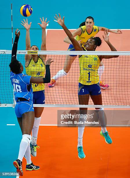 Paola Egonu of Italy spikes the ball as Dani Lins and Fabiana Claudino of Brazil defend during the match between Brazil and Italy on day 1 the FIVB...