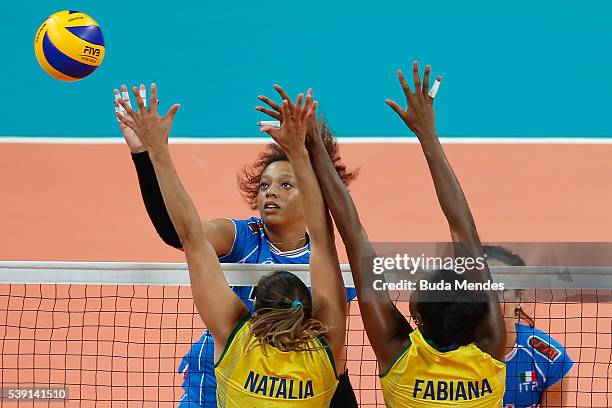 Valentina Diouf of Italy spikes the ball as Natalia Pereira and Fabiana Claudino of Brazil defend during the match between Brazil and Italy on day 1...