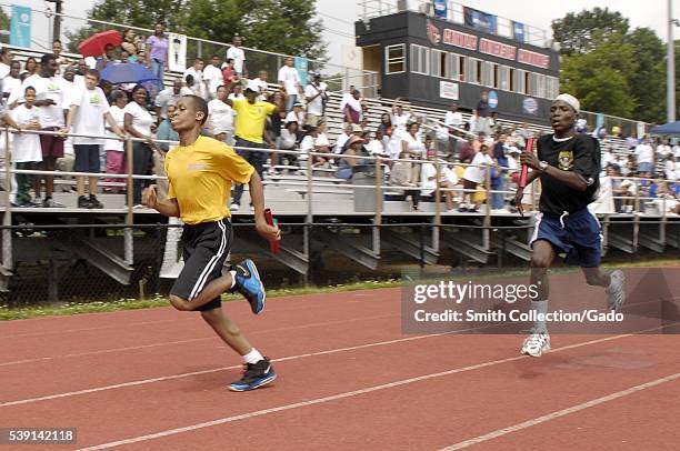 Runners at the 2012 Washington DC Special Olympics represent the US Navy and Army during a 4x100 meter relay race at the 2012 Washington DC Special...