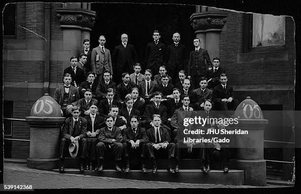 Group portrait of the Johns Hopkins University class of 1905 gathered on the steps to a large brick building in Baltimore, Maryland, 1905. .