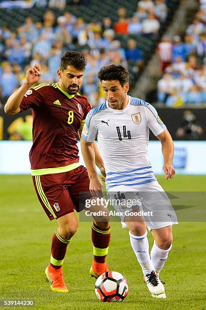 Nicolas Lodeiro of Uruguay runs past Tomas Rincon of Venezuela during a group C match between Uruguay and Venezuela at Lincoln Financial Field as...