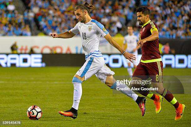 Gaston Silva of Uruguay dribbles past Tomas Rincon of Venezuela during a group C match between Uruguay and Venezuela at Lincoln Financial Field as...