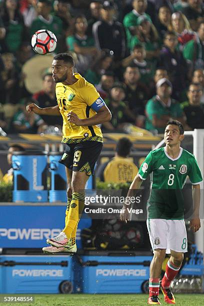 Giles Barnes of Jamaica heads the ball while observed by Hirving Lozano of Mexico during a group C match between Jamaica and Mexico at Rose Bowl as...