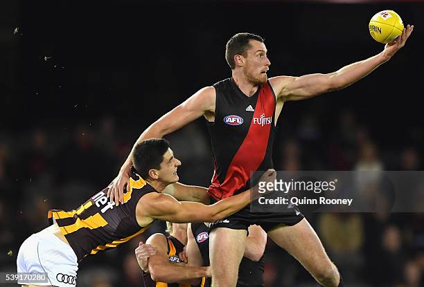 Matthew Leuenberger of the Bombers is tackled by Marc Pittonet of the Hawks during the round 12 AFL match between the Essendon Bombers and the...