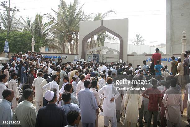 People gather at the site after the roof collapsed during the first Friday Prayer in the Muslim holy fasting month of Ramadan at the Usman Ghani...