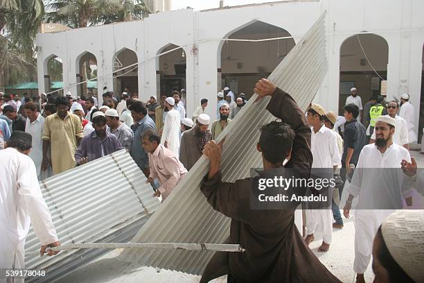 People gather at the site after the roof collapsed during the first Friday Prayer in the Muslim holy fasting month of Ramadan at the Usman Ghani...