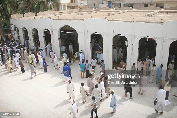 People gather at the site after the roof collapsed during the first Friday Prayer in the Muslim holy fasting month of Ramadan at the Usman Ghani...