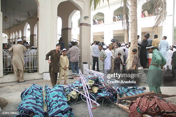 People gather at the site after the roof collapsed during the first Friday Prayer in the Muslim holy fasting month of Ramadan at the Usman Ghani...