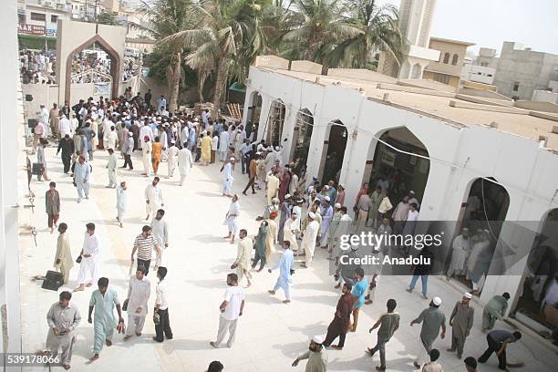 People gather at the site after the roof collapsed during the first Friday Prayer in the Muslim holy fasting month of Ramadan at the Usman Ghani...