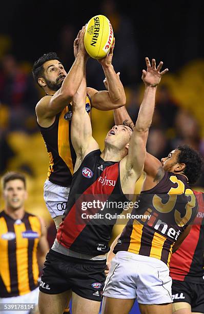 Paul Puopolo of the Hawks marks over the top of Matt Dea of the Bombers during the round 12 AFL match between the Essendon Bombers and the Hawthorn...