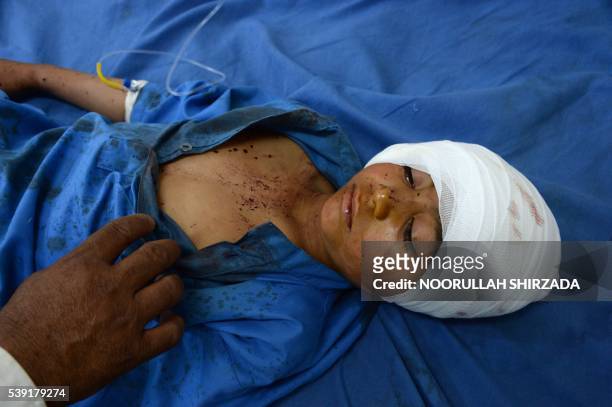 An Afghan wounded boy receives treatment at a hospital following an explosion inside a mosque in the Rodat district of Nangarhar province on June 10,...