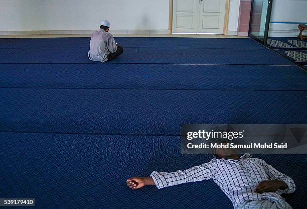 An Indian Muslim man is seen sleep inside the India Muslim mosque during the holy month of Ramadan on June 10, 2016 in Klang, Malaysia. Muslims...