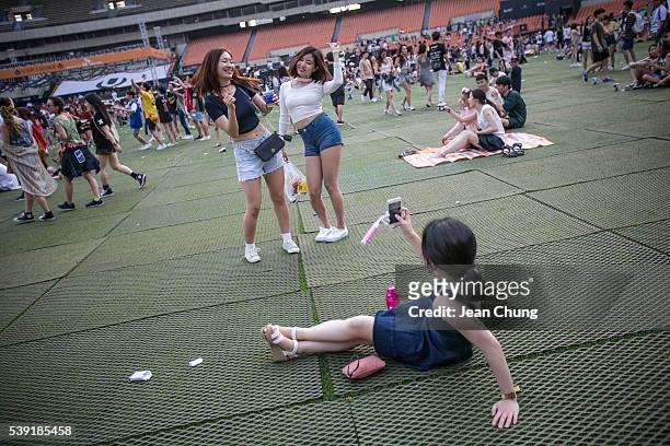 South Korean youths take snapshots while they dance to electronic music during the Ultra Music Festival Korea at Olympic Stadium on June 10, 2016 in...