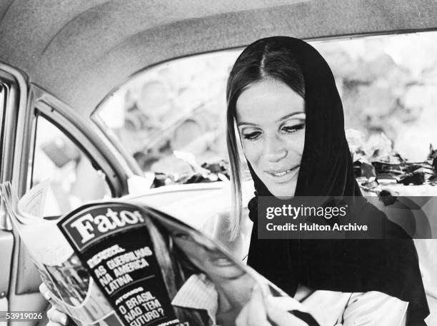German countess and fashion model Veruschka reads a Fatos Magazine with her face on the cover, Rio de Janeiro, Brazil, September 1967.
