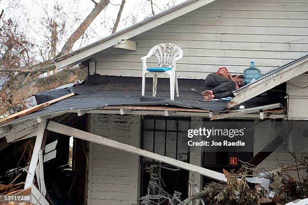 Man sleeps on the roof of his porch after Hurricane Katrina destroyed his home September 1, 2005 in Biloxi, Mississippi. Most local residents and...