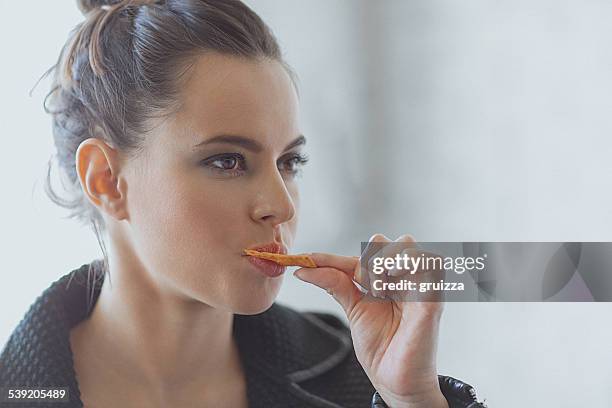 schöne junge frau essen müsli-bar, snack - crackers stock-fotos und bilder