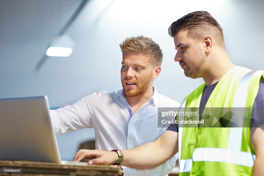 Young manager working with foreman in factory